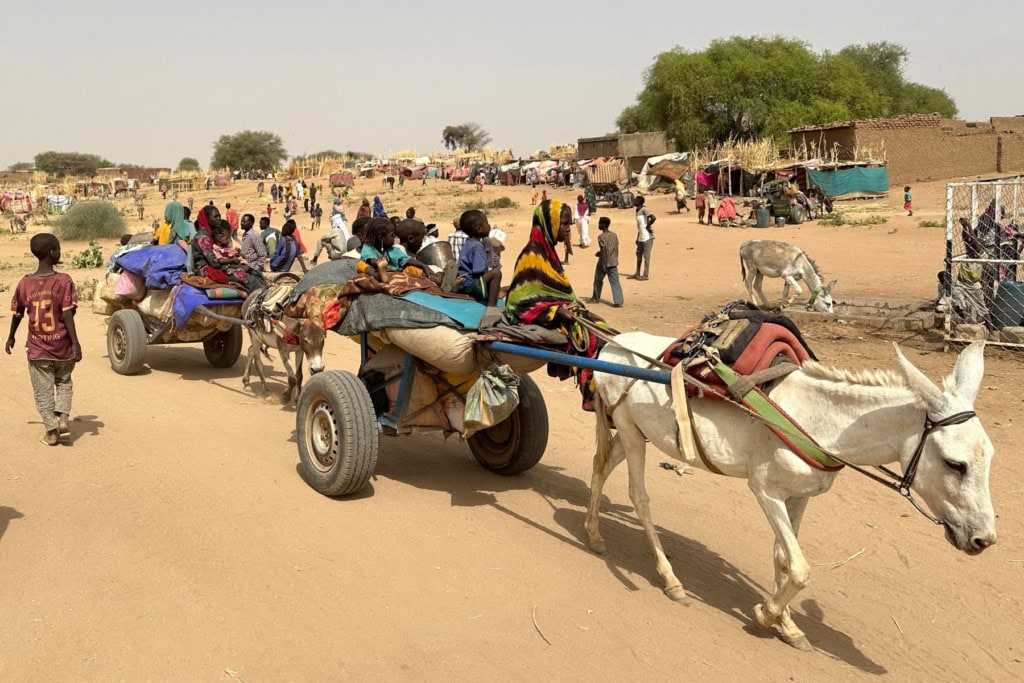People who fled the Zamzam camp for the internally displaced after it fell under RSF control, arrive with their belongings on donkey carts to a makeshift encampment in an open field near the town of Tawila in war-torn Sudan's western Darfur region on April 13, 2025. Photo by -/AFP via Getty Images.