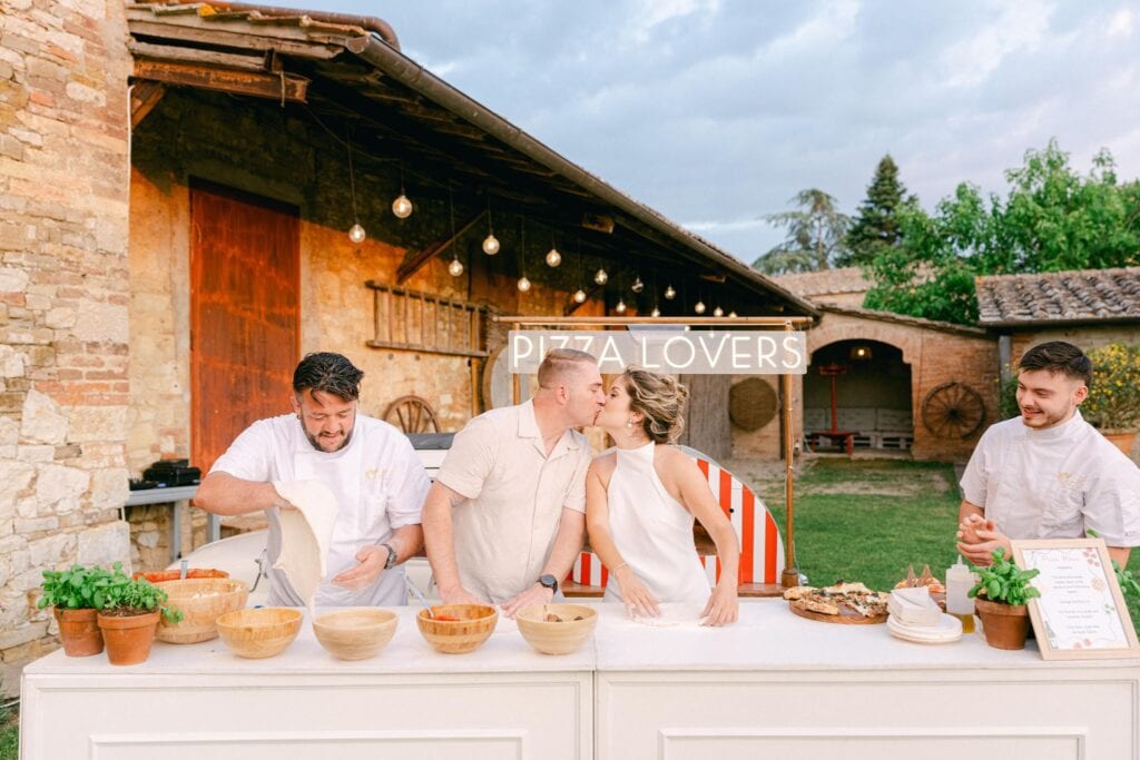 Bride and groom making pizza during their wedding weekend