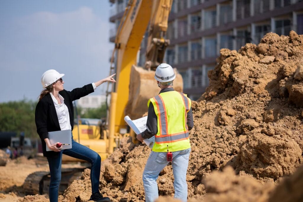 Ingeniera y supervisor en obra de construcción moderna, símbolo de supervisión técnica, innovación y planificación arquitectónica.