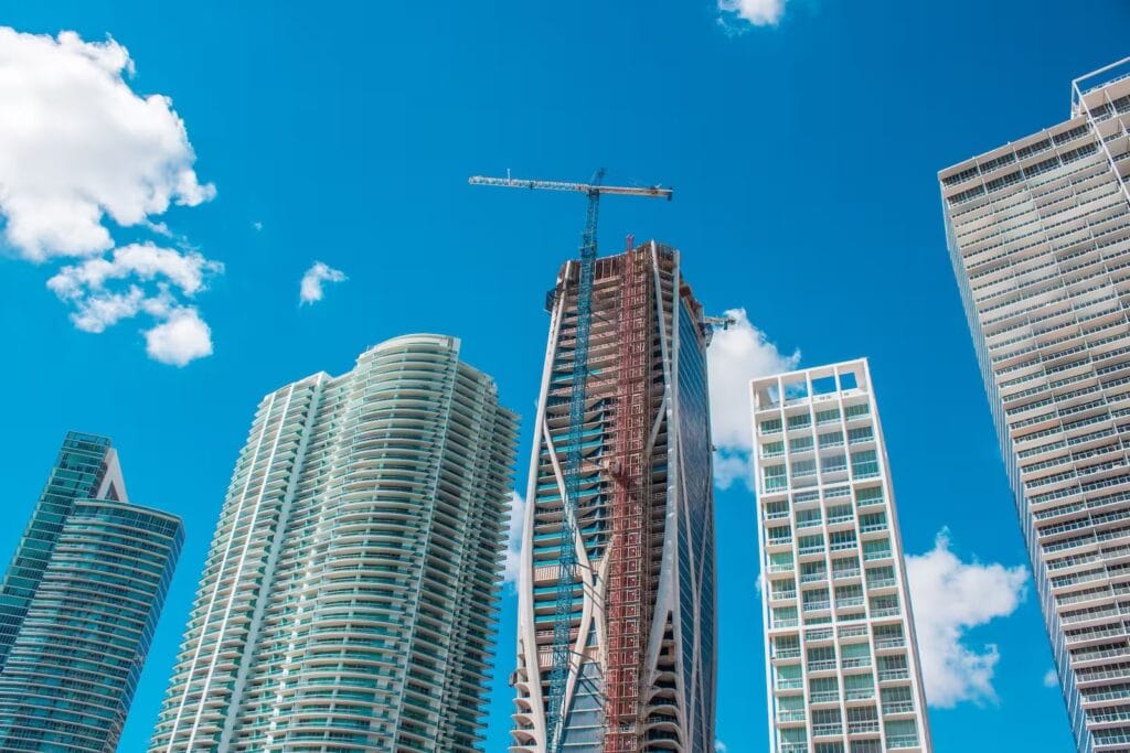 Rascacielos modernos bajo cielo azul, símbolo de arquitectura urbana, innovación y desarrollo inmobiliario contemporáneo.