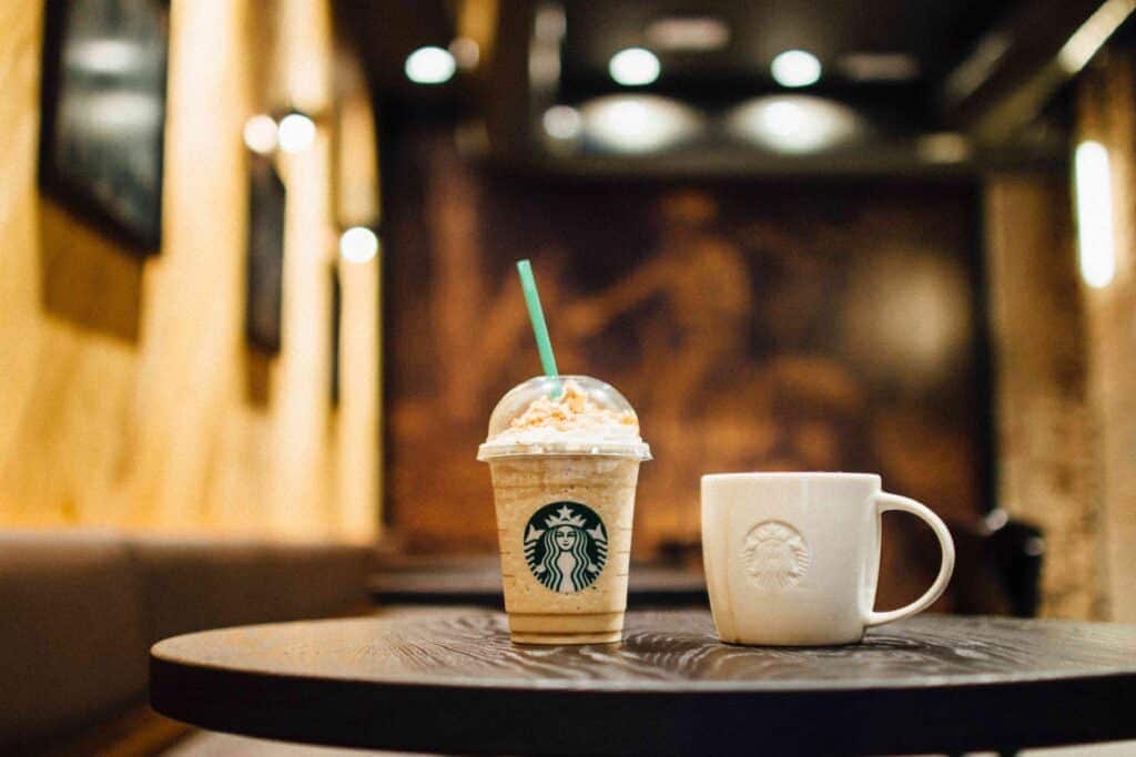 Starbucks Frappuccino and a coffee mug on a table.