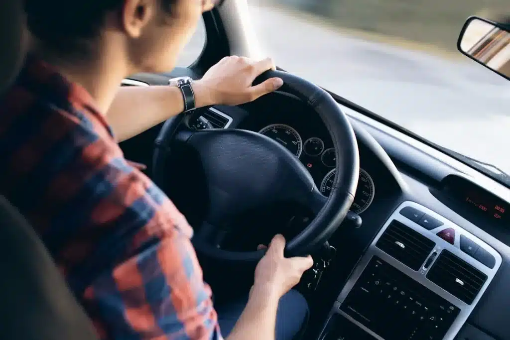 person test driving a used car