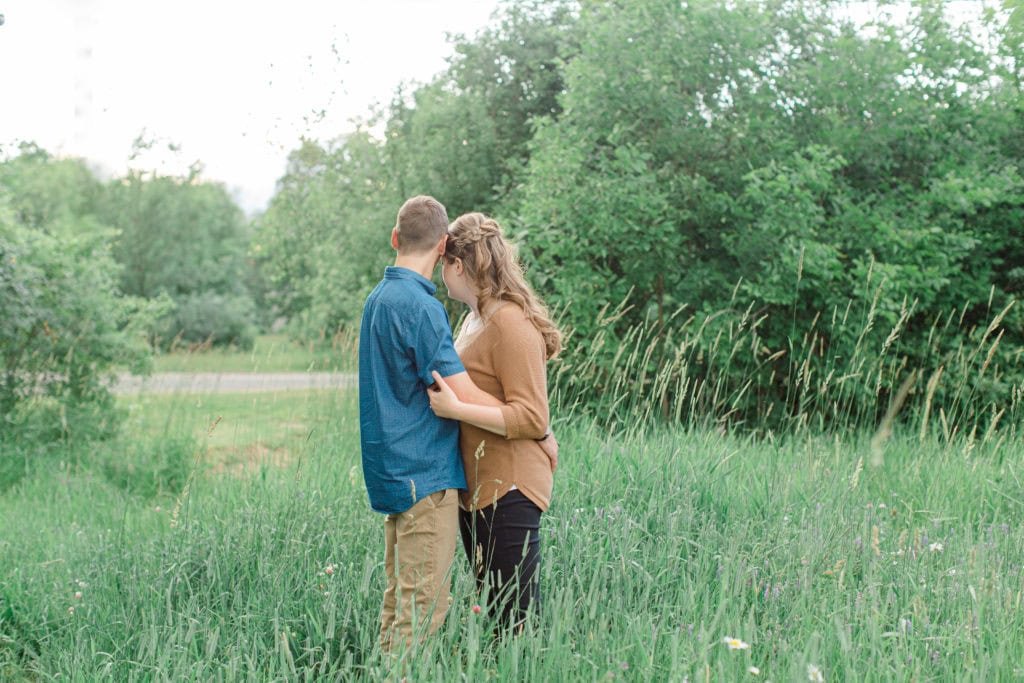 Poses during Engagement Session Sunset - Natural Posing for Photo Session - Couples Photo Session Fun - Fun on the Farm - Farm Engagement Session - Blue and Brown Engagement Session Inspiration - Natural Engagement Session Posing - Ideas for what to wear for Engagement Photography, Modern Engagement Session Inspiration Wardrobe Ideas. Unsure of what to wear for your engagement photos, we've got you! Romantic brown with black leggings for Summer Engagement in Almonte. Grey Loft Studio is Ottawa's Wedding and Engagement Photographer for Real couples, showcasing photos that are modern, bright, and fun.
