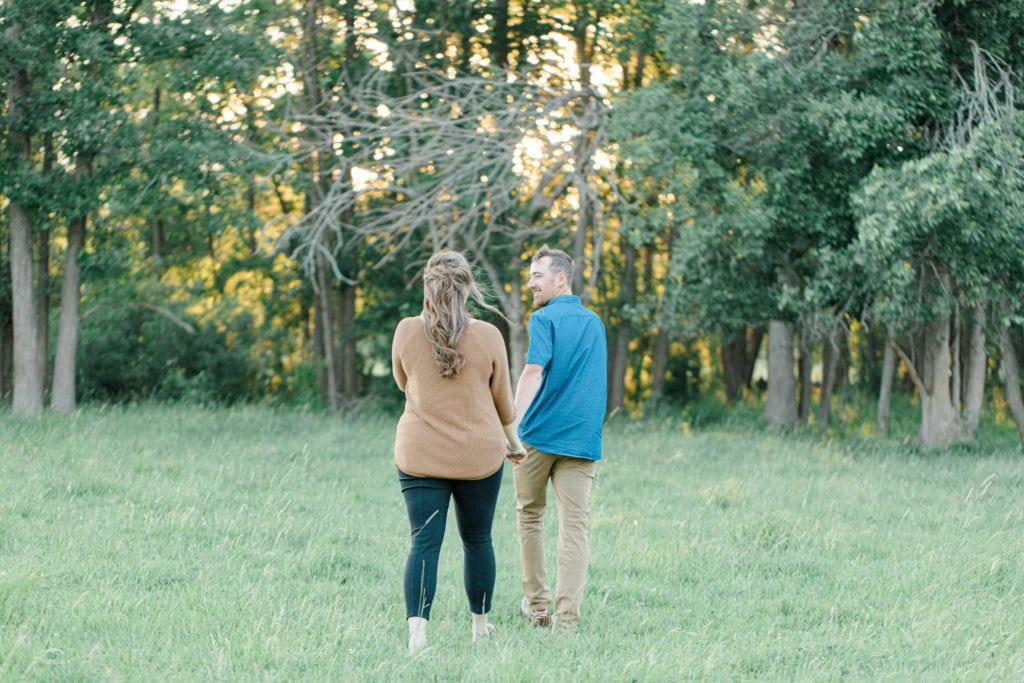 Cows during Engagement Session - Poses during Engagement Session Sunset - Natural Posing for Photo Session - Couples Photo Session Fun - Fun on the Farm - Farm Engagement Session - Blue and Brown Engagement Session Inspiration - Natural Engagement Session Posing - Ideas for what to wear for Engagement Photography, Modern Engagement Session Inspiration Wardrobe Ideas. Unsure of what to wear for your engagement photos, we've got you! Romantic brown with black leggings for Summer Engagement in Almonte. Grey Loft Studio is Ottawa's Wedding and Engagement Photographer for Real couples, showcasing photos that are modern, bright, and fun.