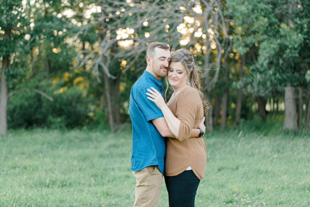 Cows during Engagement Session - Poses during Engagement Session Sunset - Natural Posing for Photo Session - Couples Photo Session Fun - Fun on the Farm - Farm Engagement Session - Blue and Brown Engagement Session Inspiration - Natural Engagement Session Posing - Ideas for what to wear for Engagement Photography, Modern Engagement Session Inspiration Wardrobe Ideas. Unsure of what to wear for your engagement photos, we've got you! Romantic brown with black leggings for Summer Engagement in Almonte. Grey Loft Studio is Ottawa's Wedding and Engagement Photographer for Real couples, showcasing photos that are modern, bright, and fun.
