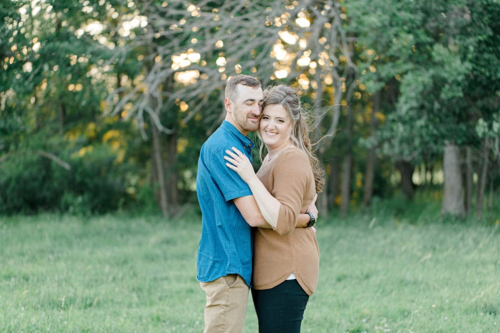 Cows during Engagement Session - Poses during Engagement Session Sunset - Natural Posing for Photo Session - Couples Photo Session Fun - Fun on the Farm - Farm Engagement Session - Blue and Brown Engagement Session Inspiration - Natural Engagement Session Posing - Ideas for what to wear for Engagement Photography, Modern Engagement Session Inspiration Wardrobe Ideas. Unsure of what to wear for your engagement photos, we've got you! Romantic brown with black leggings for Summer Engagement in Almonte. Grey Loft Studio is Ottawa's Wedding and Engagement Photographer for Real couples, showcasing photos that are modern, bright, and fun.