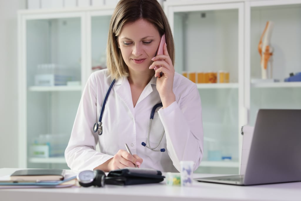 Vitamin B12 Infusion Therapy 13 female-doctor-does-phone-call-with-patient-give-online-consultation-sitting-table