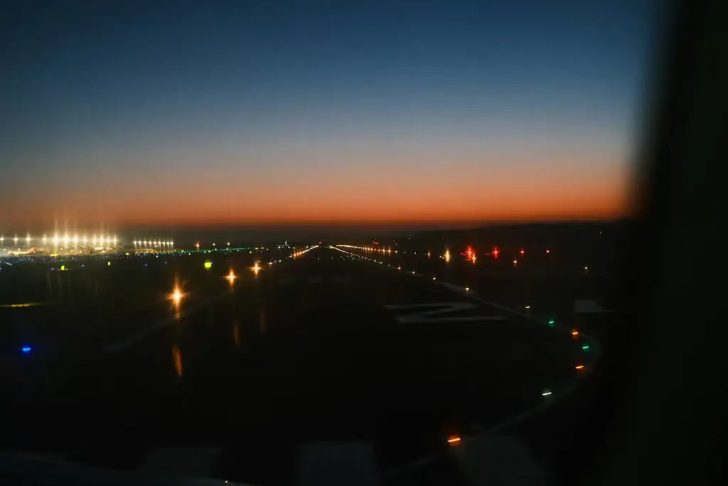 An empty airport runway at dusk with approach and edge lights on and no aircraft — Ukrainian airspace closed to civil traffic