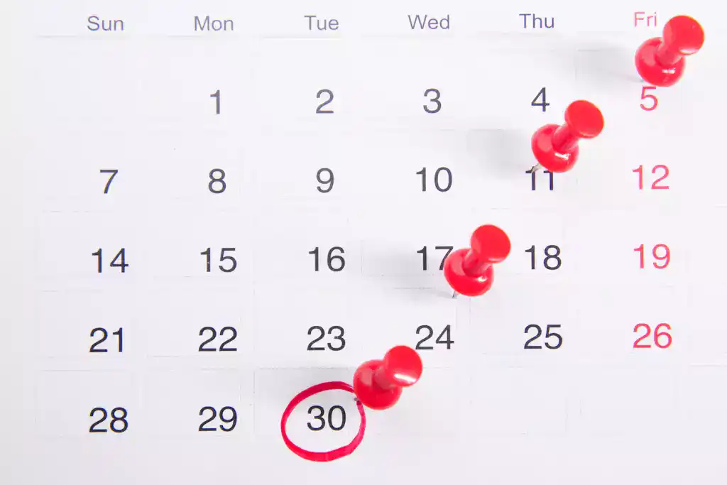 Wall calendar with red pins on successive weeks and one date circled