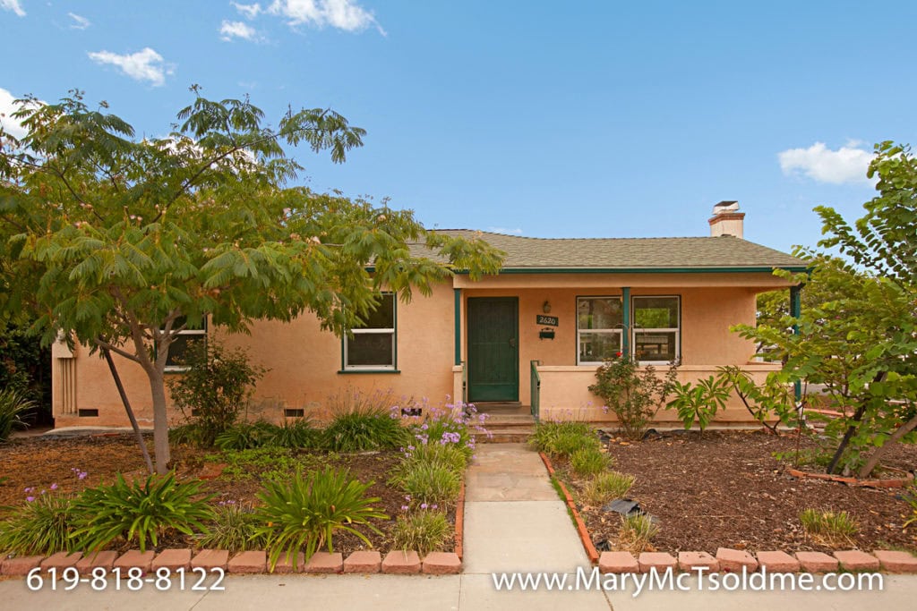 Charming single-story home at 2620 Boundary Street in North Park with peach stucco, a green front door, and a landscaped front yard with a stone walkway.