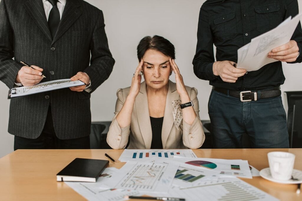 A Person Holding her Temples Deciding on Some Paperwork