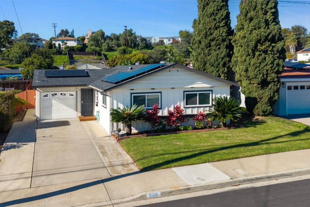 High-angle street view of 2170 Montclair St in North Park showing the driveway, garage, and manicured lawn.