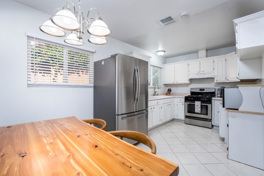 Kitchen and dining area at 2170 Montclair St in North Park featuring a wooden dining table and painted cabinetry.