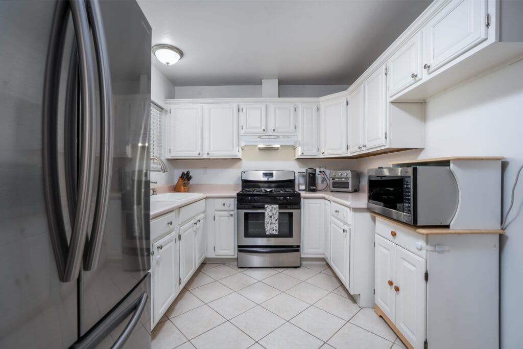 Open concept kitchen at 2170 Montclair St North Park featuring white cabinetry, stone countertops, and stainless steel appliances.
