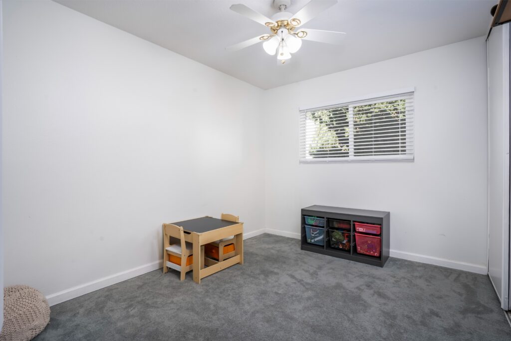 Spacious secondary bedroom or nursery at 2170 Montclair St in North Park featuring plush grey carpet and a bright, airy atmosphere.