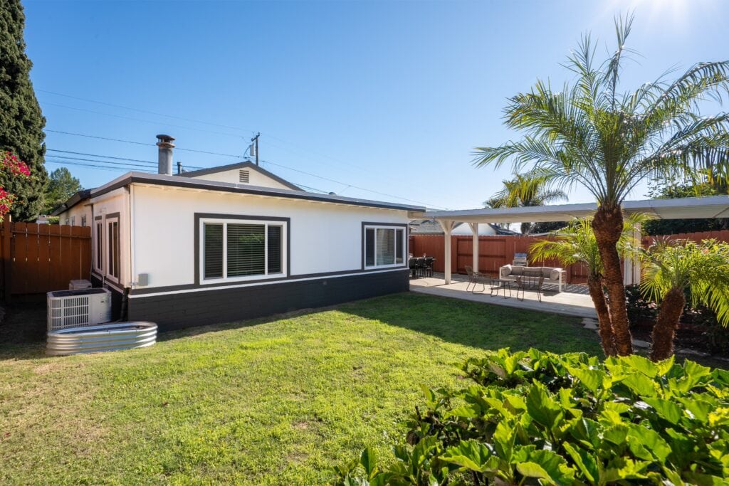 Exterior shot of 2170 Montclair St showcasing the modern HVAC system, newer mini-split, and the home's proximity to the large entertainer’s patio.