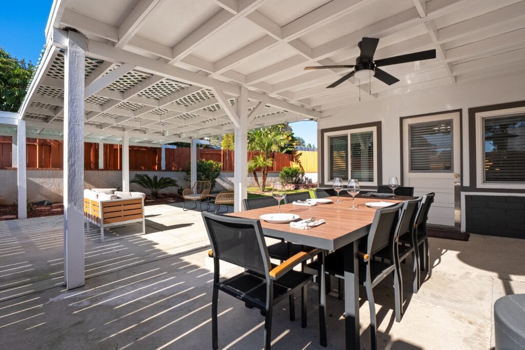 Luxury outdoor dining area at 2170 Montclair St in North Park, San Diego, featuring a weather-protected pergola, ceiling fan, and modern patio furniture for entertainer’s dream backyard.