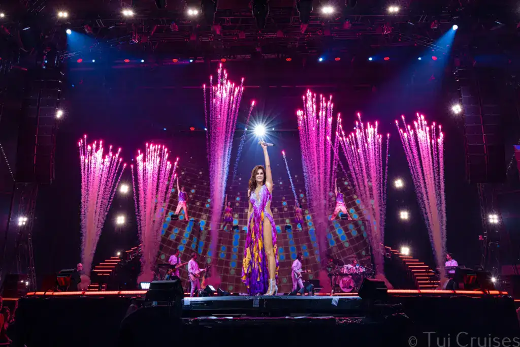 Andrea_Berg - Michis Kreuzfahrten andrea berg performing on stage surrounded by colorful lights and water fountains during a concert.