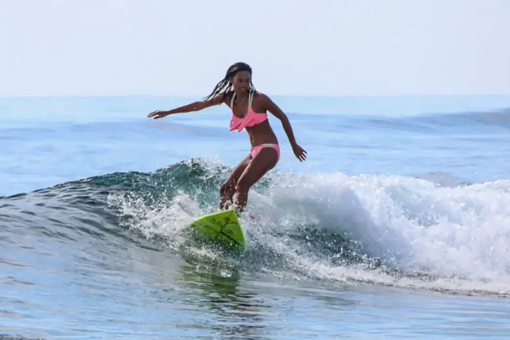 A picture of a young woman surfing in Siargao, Philippines.