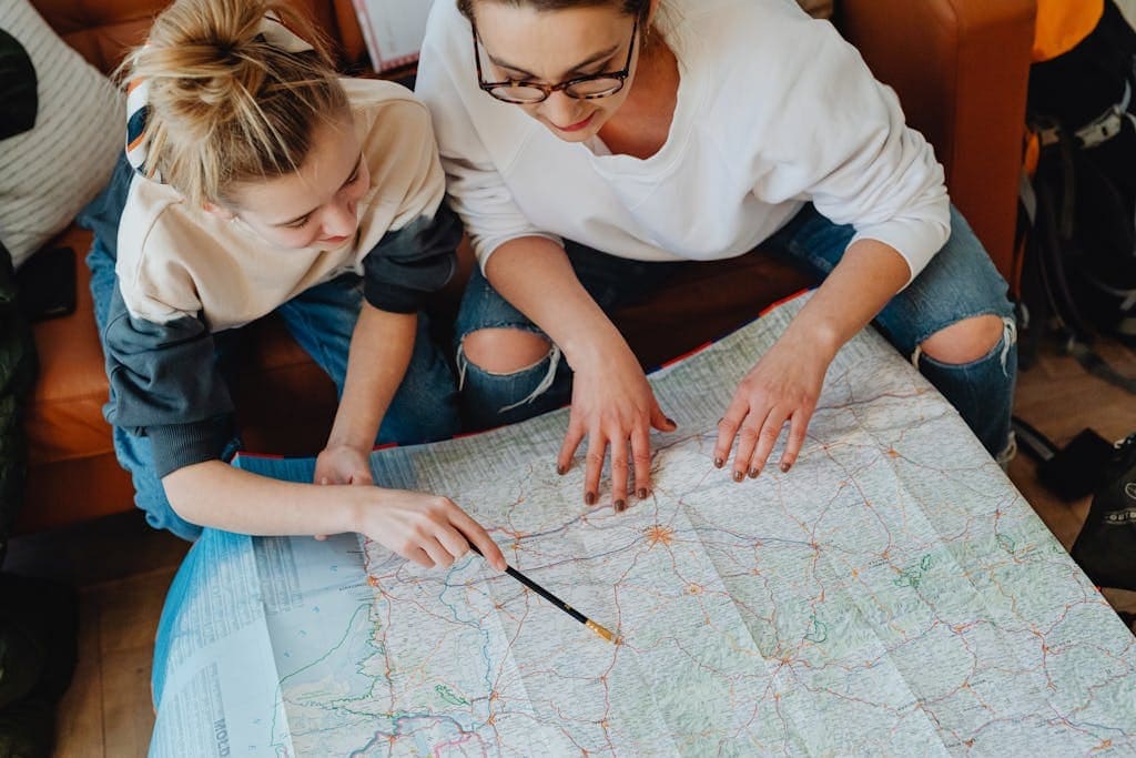 A mother and daughter plan their journey using a map, symbolizing adventure and bonding. This image is the featured image in the blog post Accessible Travel Guide