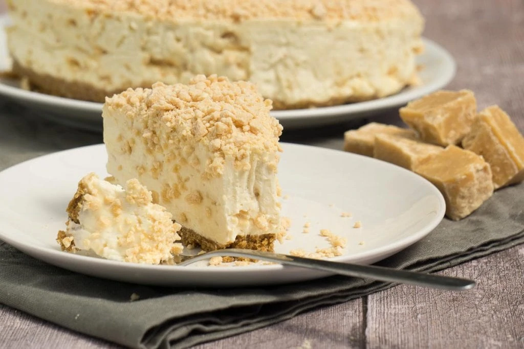 Scottish Tablet Cheesecake on a plate with a bite taken out of it with a fork