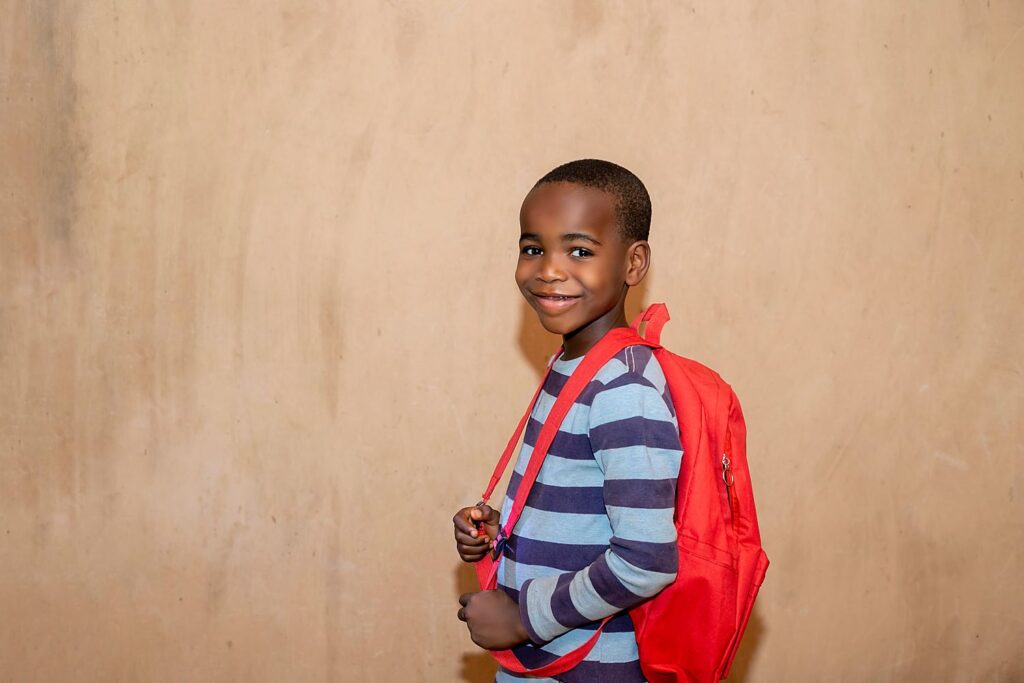 Un écolier avec son cartable rouge, à Dakar