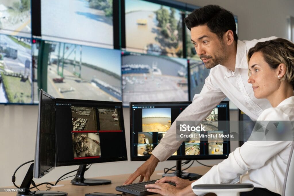 People monitoring surveillance footage on multiple screens.