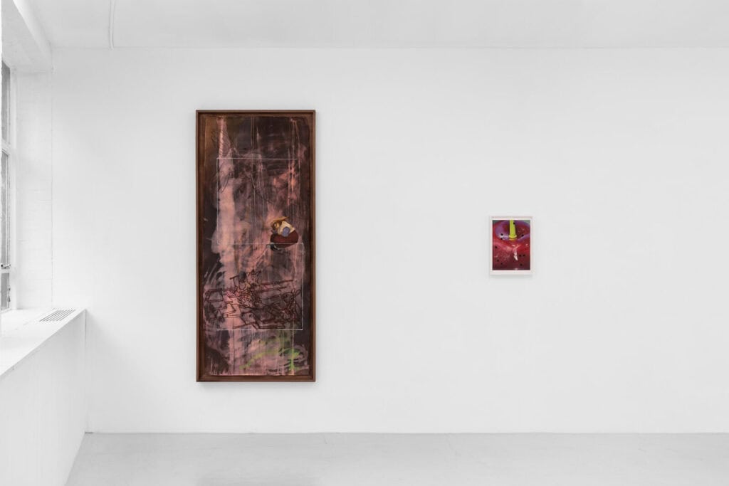 A minimalist gallery with white walls displays two abstract paintings: one large, vertical piece with dark red and brown tones on the left, and a smaller work on the right. Natural light enters from a window at ‘Abigail’s Party’ at Rose Easton Gallery.