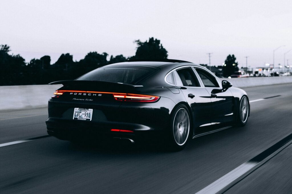 Black saloon car driving on the road