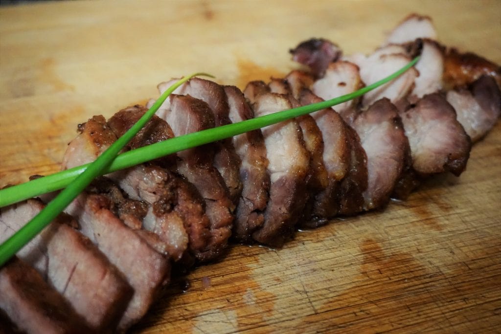 bbq pork sliced and arranged in a row