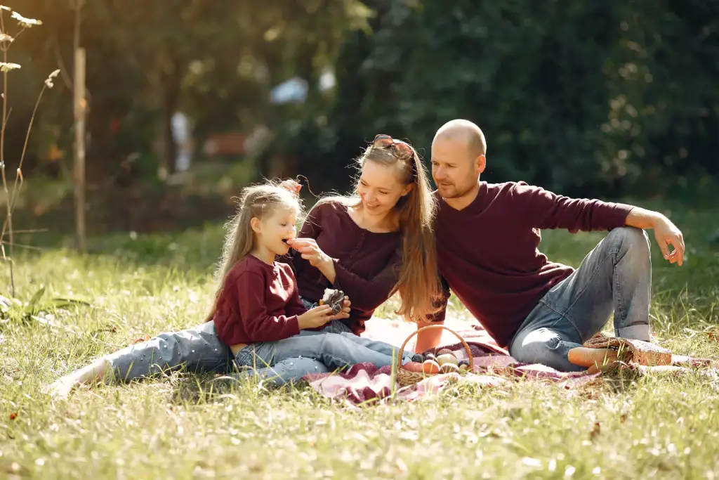 Trois générations d’une même famille dans un parc en automne, illustration de la fiscalité assurance vie succession et de la transmission d’un contrat