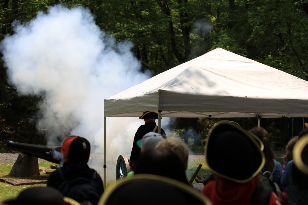 Presenter Angus MacDonald silhouetted against cannon fire