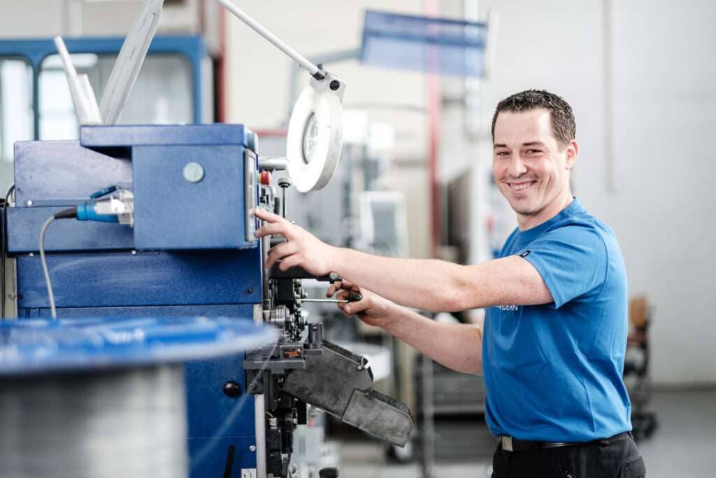Mitarbeiter bei der Präzisionsfertigung von Federn an einer modernen Maschine - Hans Ziller GmbH.