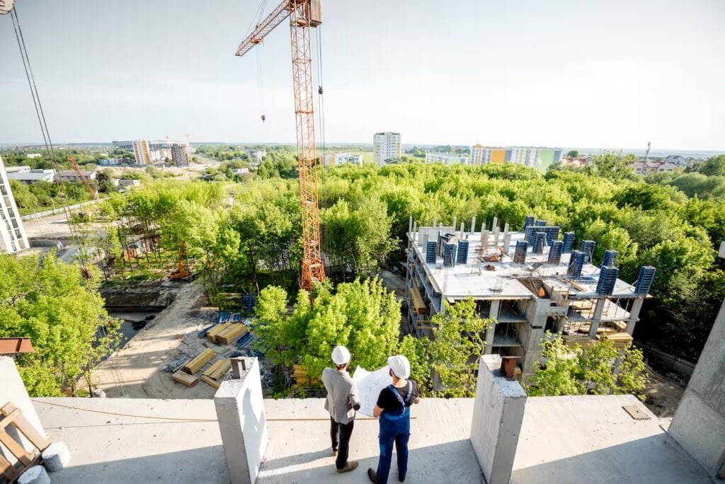 Obreros en un sitio de construcción moderna, símbolo de desarrollo urbano, ingeniería y gestión de proyectos arquitectónicos.
