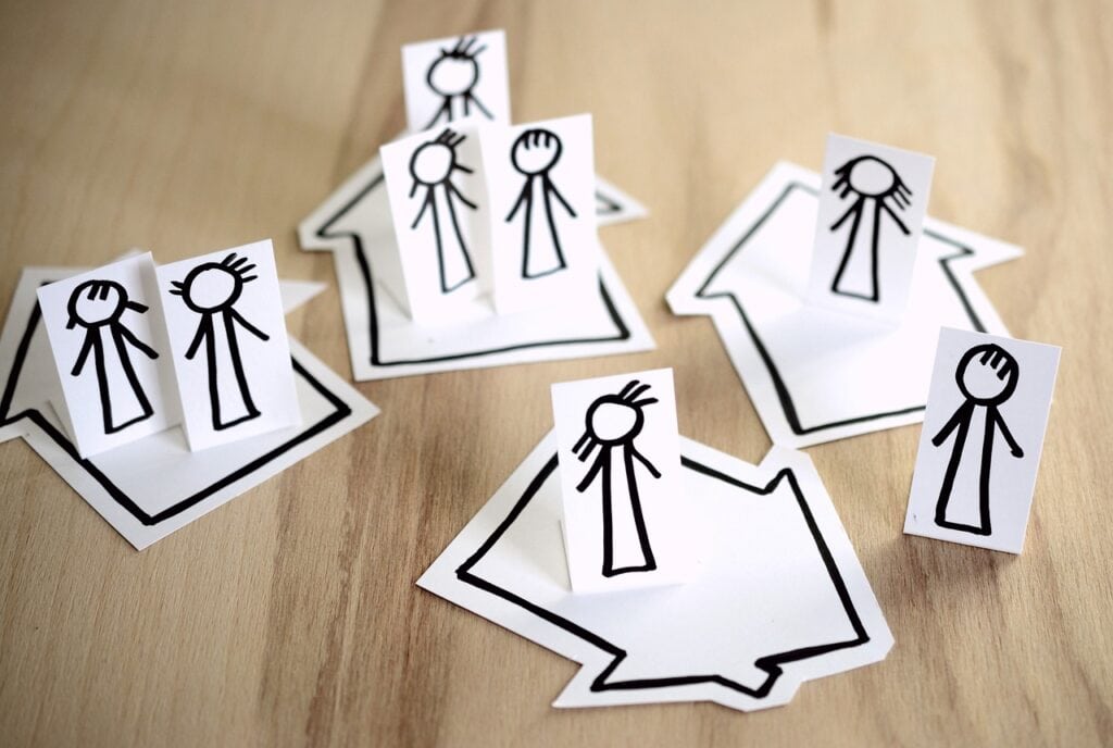 Image of stick figure families in many houses to symbolize a family isn't restricted to only those who live in the same home