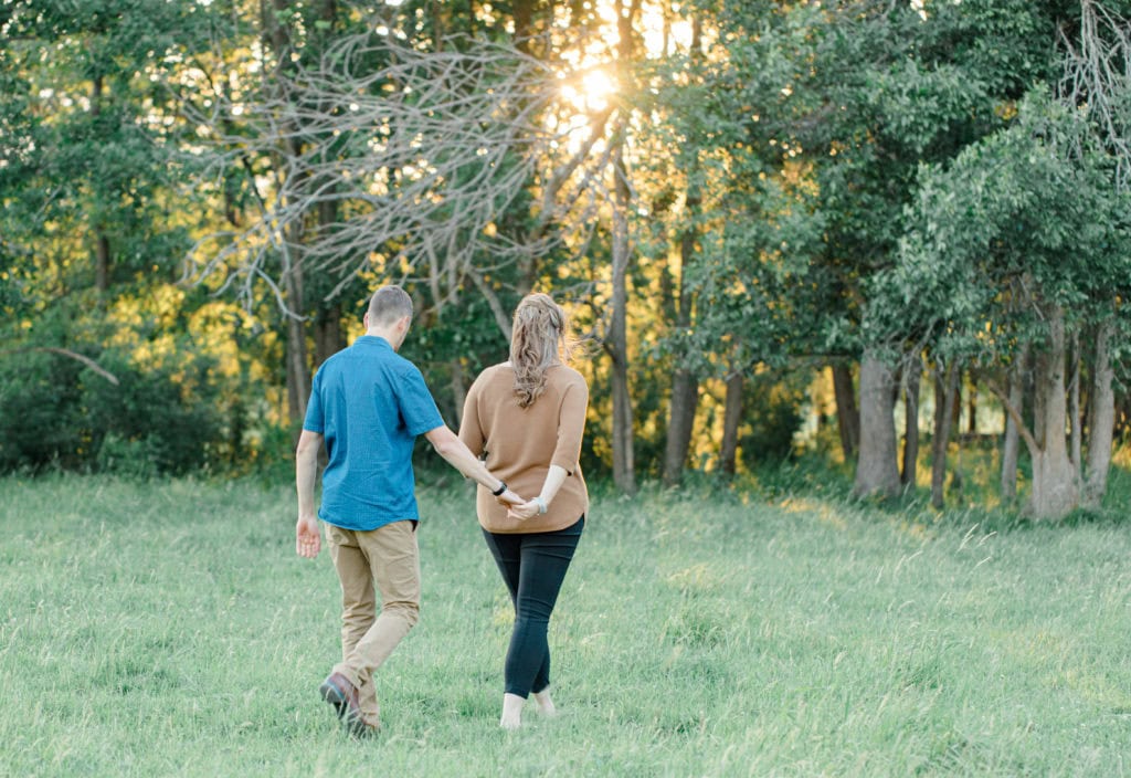Cows during Engagement Session - Poses during Engagement Session Sunset - Natural Posing for Photo Session - Couples Photo Session Fun - Fun on the Farm - Farm Engagement Session - Blue and Brown Engagement Session Inspiration - Natural Engagement Session Posing - Ideas for what to wear for Engagement Photography, Modern Engagement Session Inspiration Wardrobe Ideas. Unsure of what to wear for your engagement photos, we've got you! Romantic brown with black leggings for Summer Engagement in Almonte. Grey Loft Studio is Ottawa's Wedding and Engagement Photographer for Real couples, showcasing photos that are modern, bright, and fun.