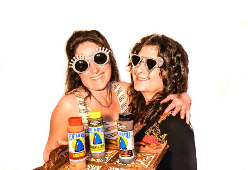 femmes tenant des bouteilles de sauces aardvark