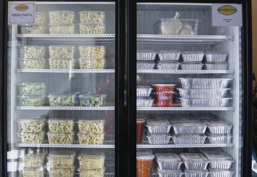 A commercial fridge stocked with Italian specialties, pastas, and sauces for grab and go dinners in Raleigh