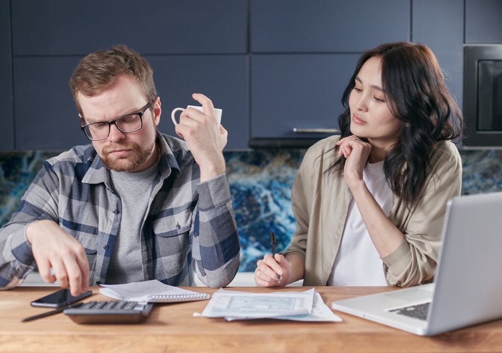 A Couple Discussing with Paperwork and a Calculator