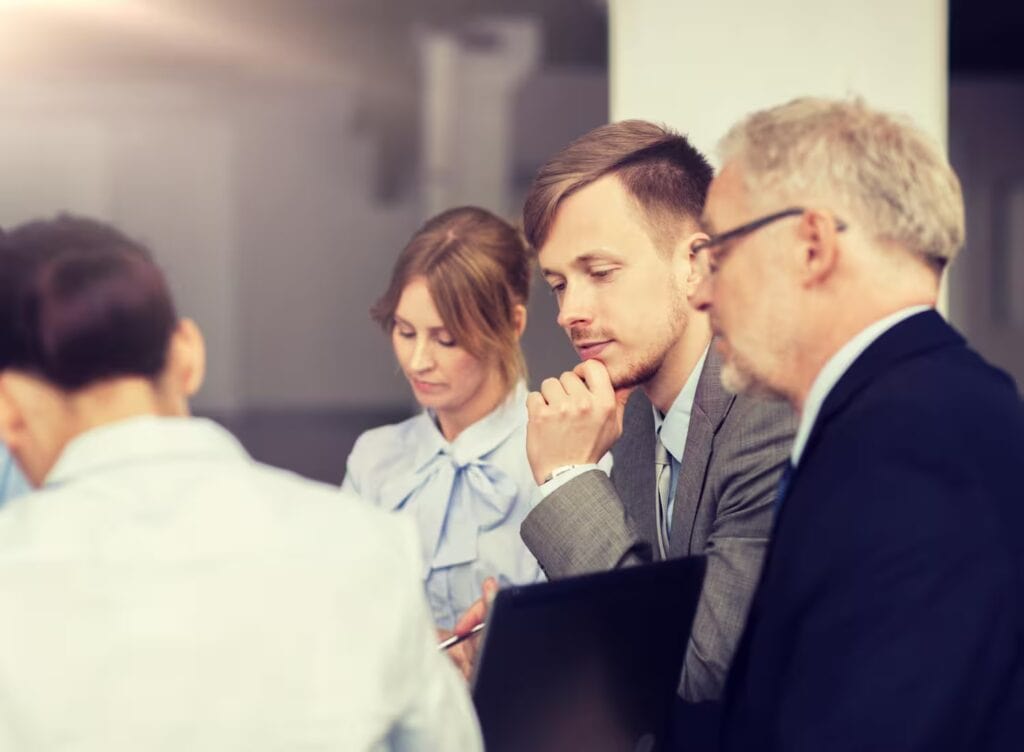 Boardroom meeting with financial analysts reviewing charts and data