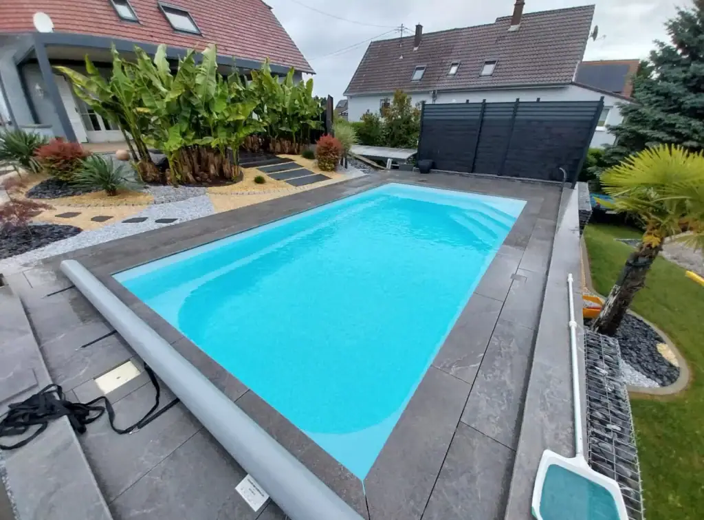 Piscine coque avec volet hors sol et aménagement extérieur