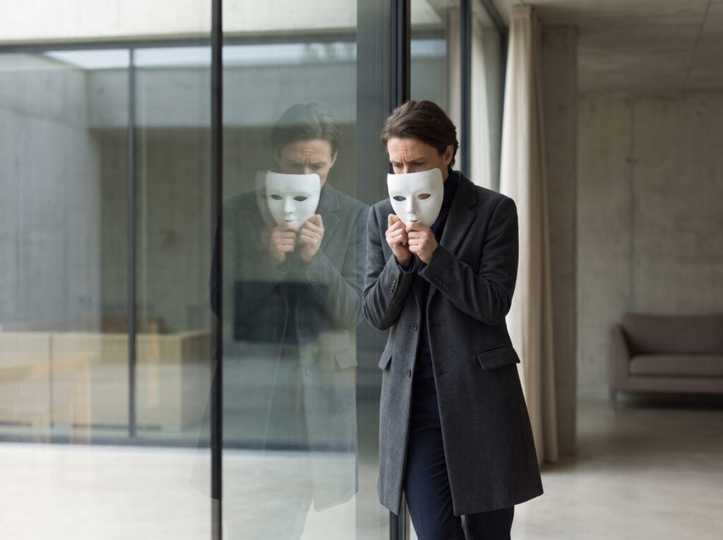 Narcisista: o que realmente está por trás de quem parece amar apenas a si mesmo? 3 Person holding mask observing re… 202607131527