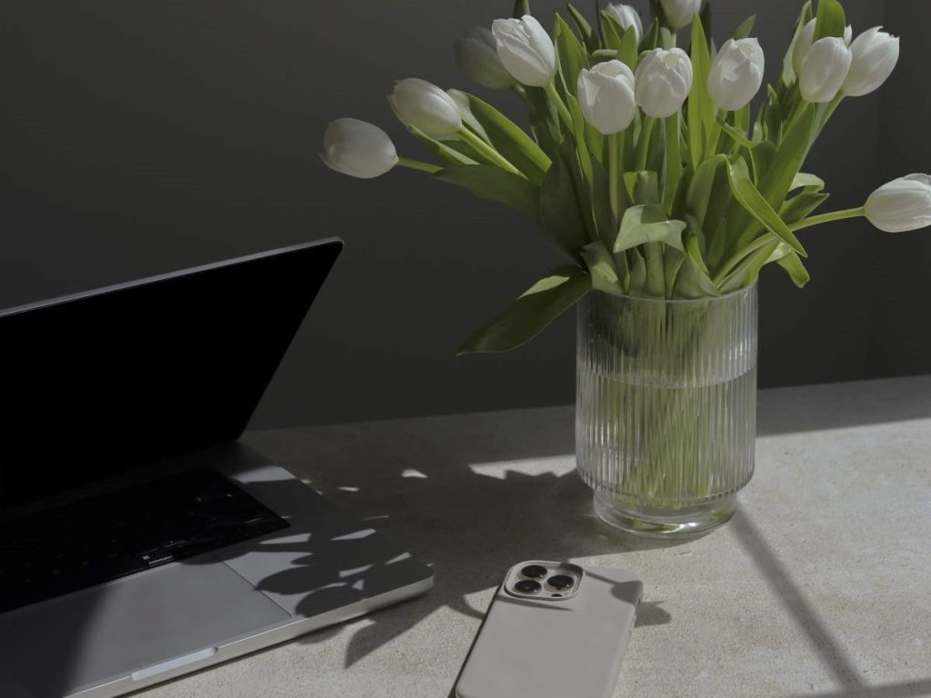 shadow on laptop from a bouquet of flowers - brightness over anxiety