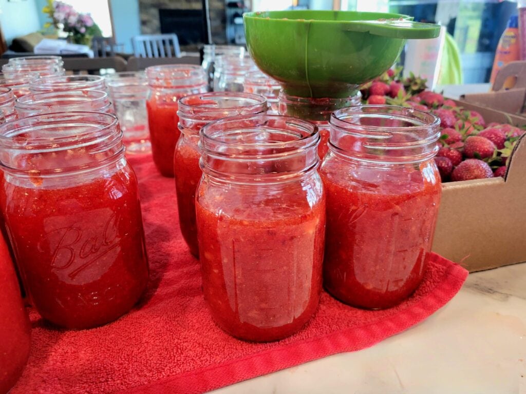 Making Strawberry Jam - Jars on Counter with funnel