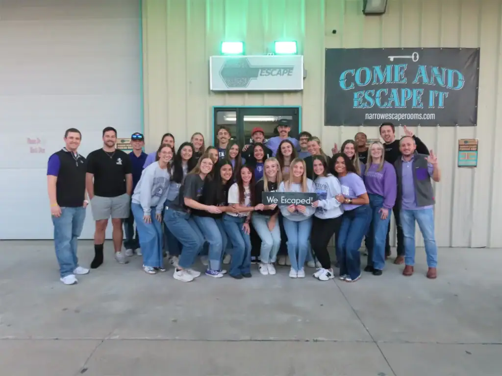 Corporate team celebrating a successful escape room challenge together