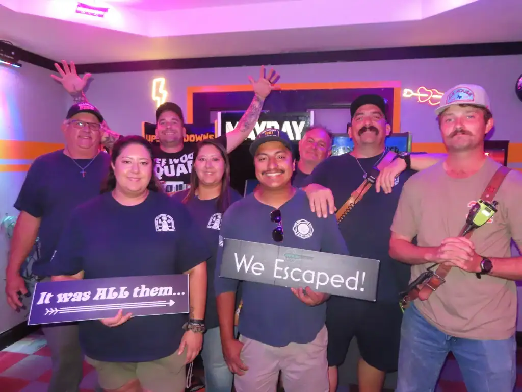 Corporate team celebrating a successful escape room challenge together