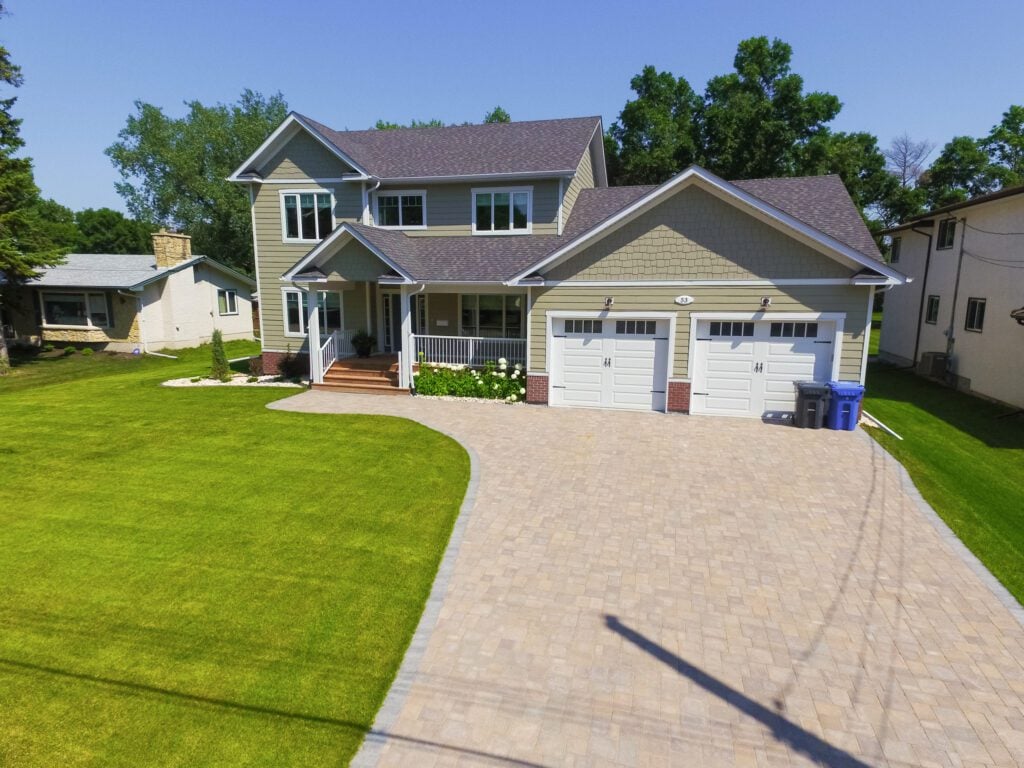 Front yard with paved driveway and professional lawn maintenance