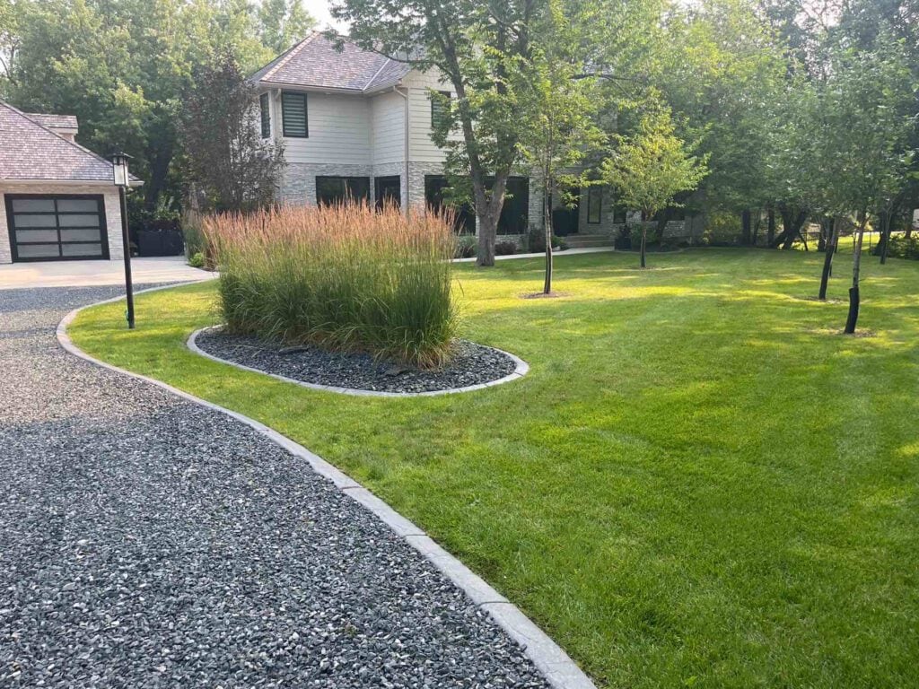 Circular stone pathway with trimmed grass and modern landscape care