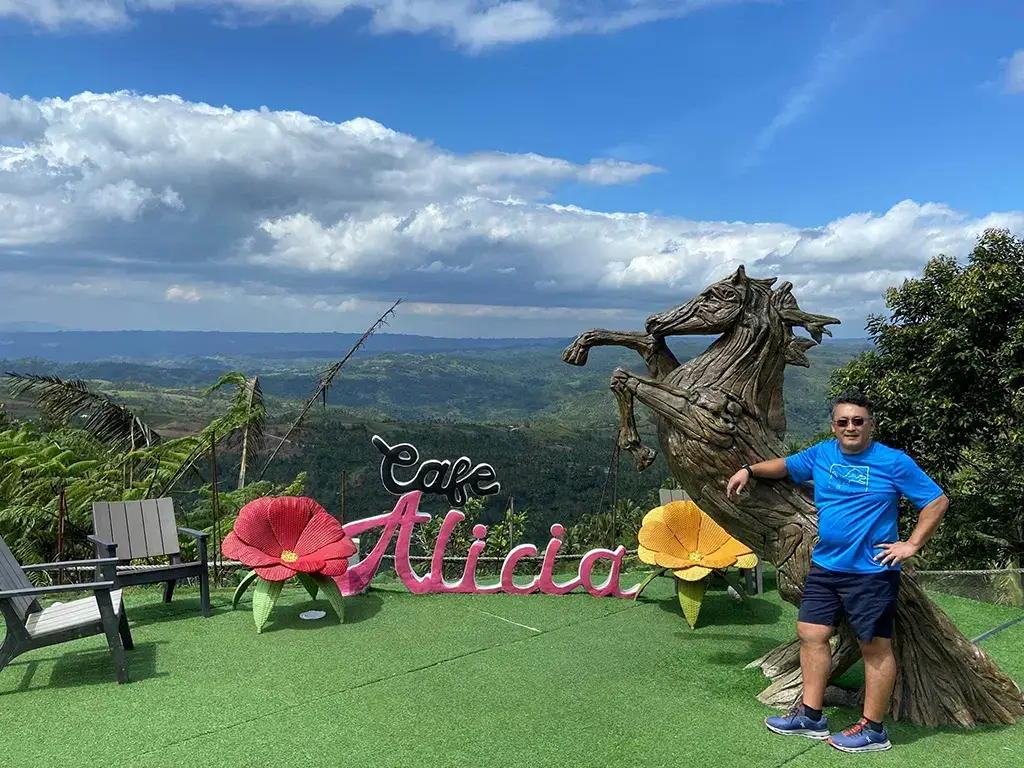 A picture of the Cafe Alicia sign overlooking the huge vast hills region!