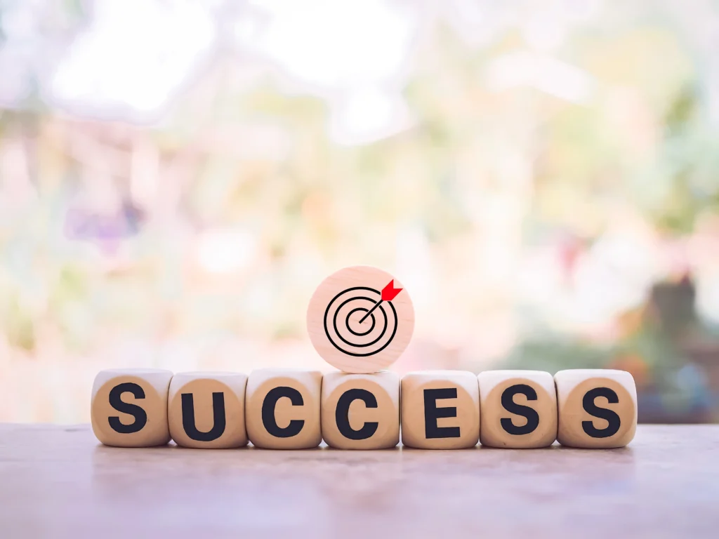 Wooden blocks spelling success with target icon, symbolizing goal achievement.